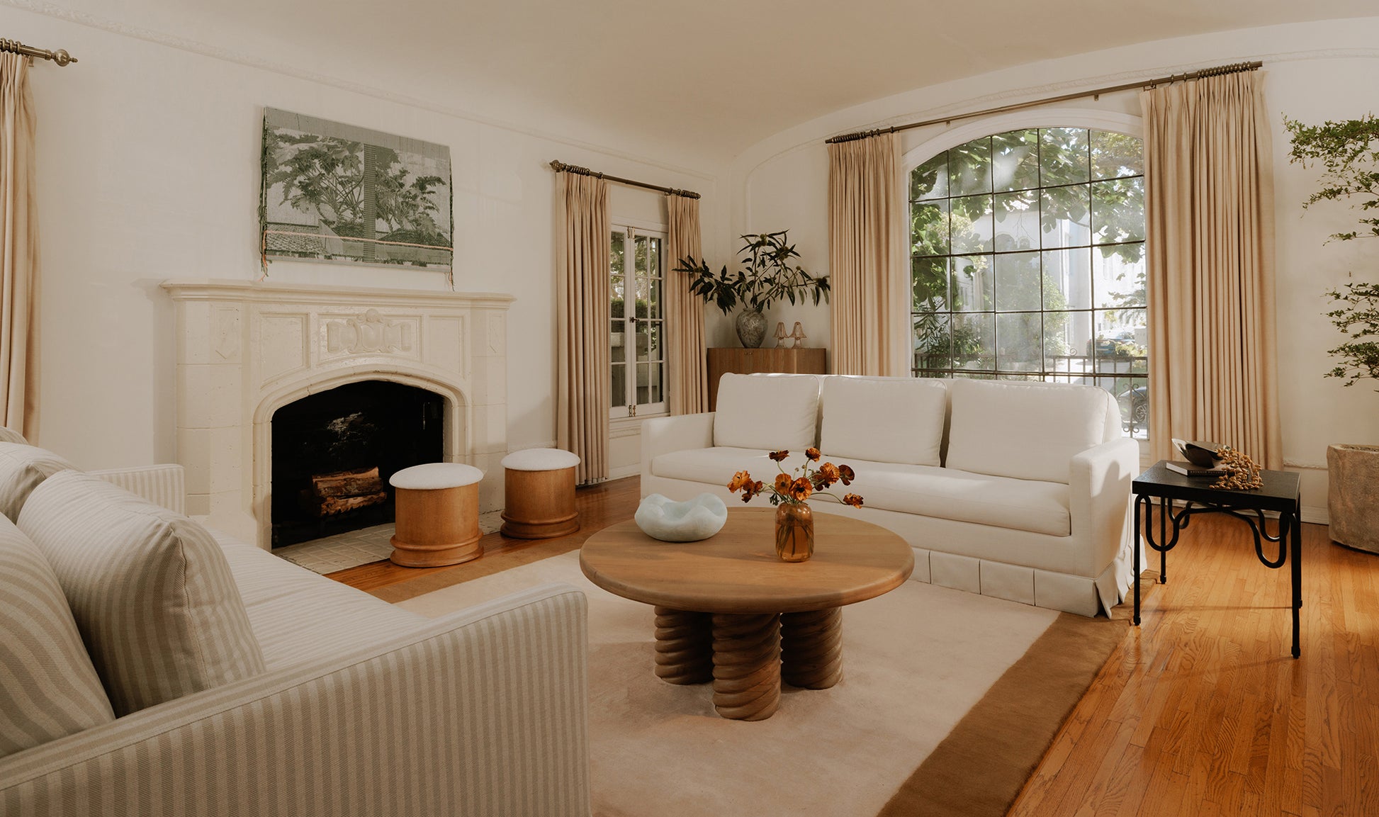 Living room with white sofas, a wooden coffee table, and a fireplace.