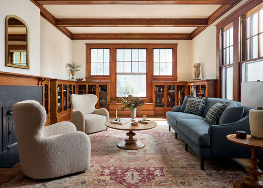 Living room with a blue sofa, white armchairs, and wooden coffee table.